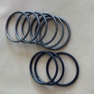 9 dark-toned, textured bangle bracelets